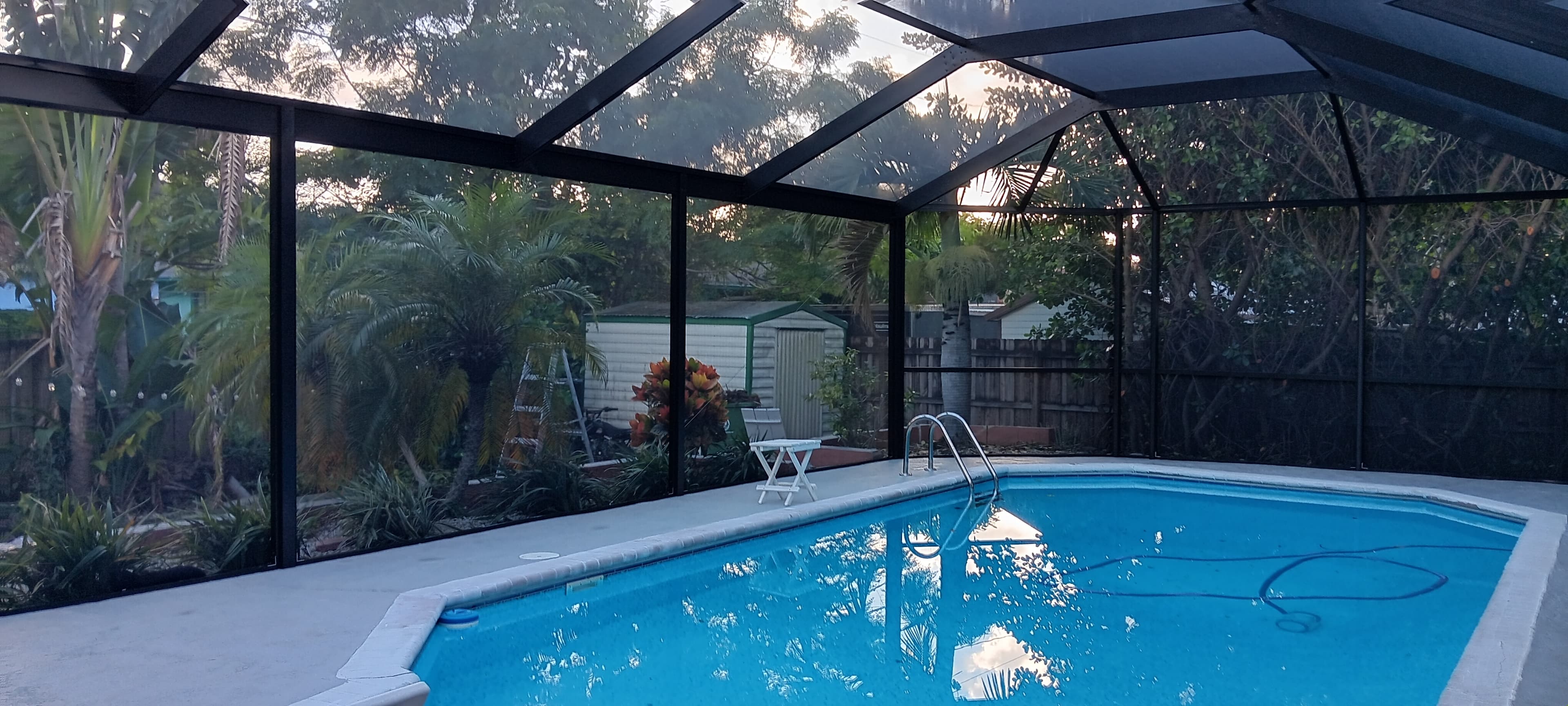 Pool enclosure with tropical landscaping in Palm Beach County